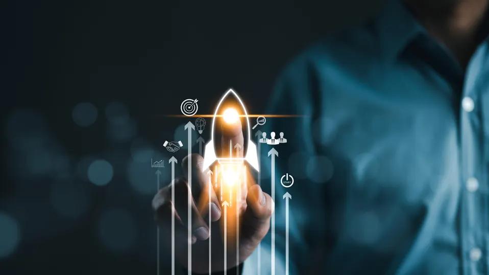 PIP PIP Hooray Close-up of a hand launching a glowing rocket, with upward arrows and business icons symbolizing startup growth and innovation.